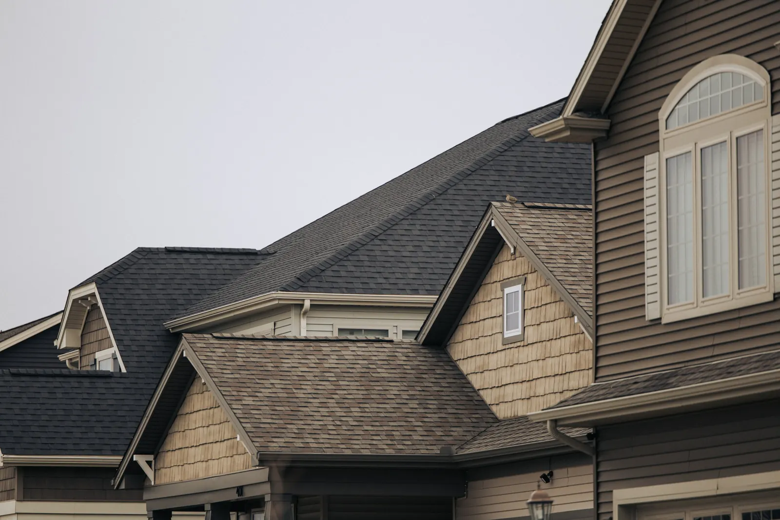 Layered gables of a two-story home with dark shingles